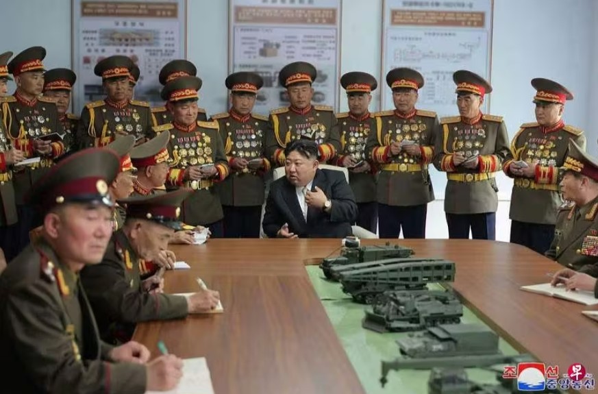 金正恩（中）到金日成军事综合大学访问
